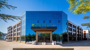 A modern building with a glass facade and a sign indicating it is a hotel.