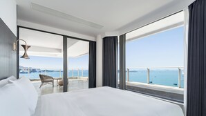 A hotel room with a large bed, a chair, a view of the sea, and a balcony. - Tiancheng Blemont Hotel Sanya, Vignette Collection by IHG (Sanya)