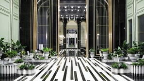 A hotel lobby with a black and white striped floor, large windows, and potted plants. - Tiancheng Blemont Hotel Sanya, Vignette Collection by IHG (Sanya)