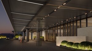 A modern building exterior with a covered walkway, large windows, and illuminated columns. - Crowne Plaza Weihai Binhai (Weihai)