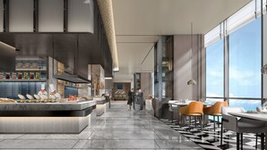 A modern restaurant with a high ceiling, a central bar area, and large windows offering a view of the sky. - Crowne Plaza Weihai Binhai (Weihai)