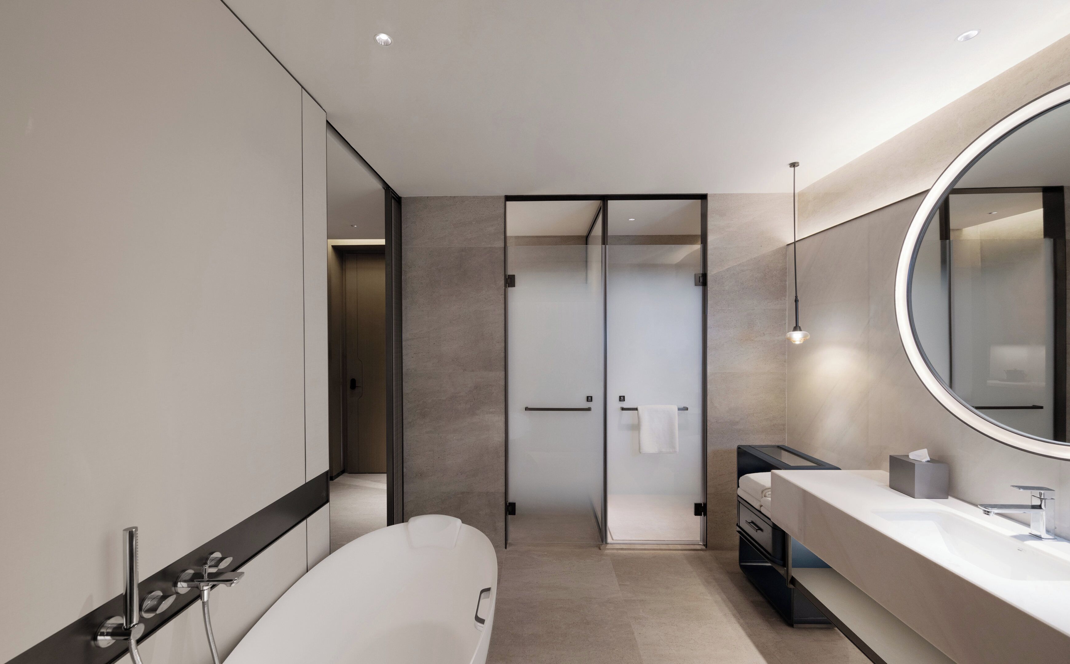 Ein modernes Badezimmer mit einer freistehenden Badewanne, einem großen Spiegel und einer Duschkabine.