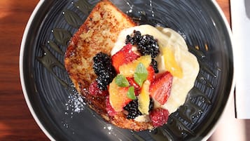 A plate with toast, fruit, and whipped cream.