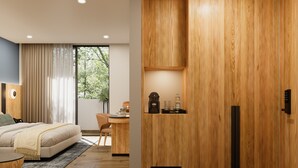 A modern bedroom with a bed, a desk, and a wardrobe.