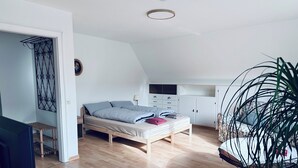 Une chambre à coucher avec un lit en bois, une armoire et un bureau.