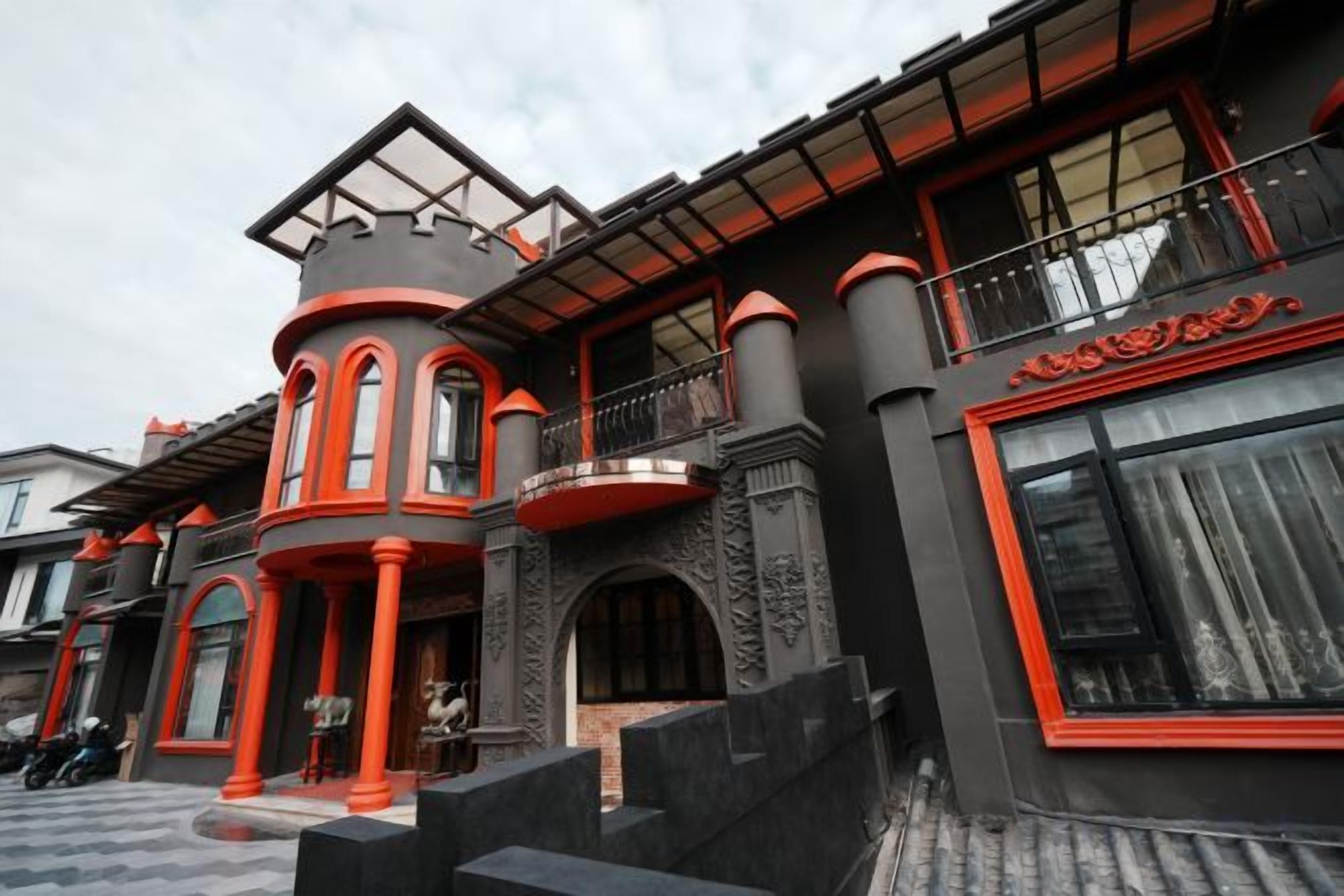 A building with a curved facade, multiple balconies, and a prominent entrance with steps.