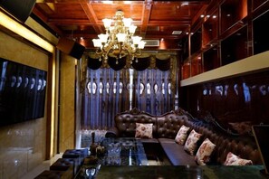 Une pièce comprenant un grand canapé richement décoré, une table basse en verre et un lustre.