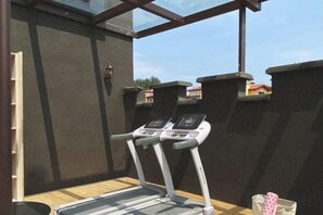 Une salle de sport équipée de tapis de course et dotée d’un plancher en bois.