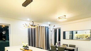 A modern kitchen with a central island, stainless steel appliances, and a dining area with a table and chairs.