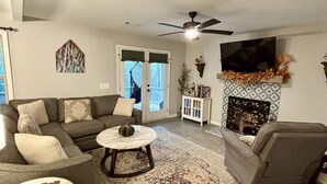 Ein Wohnzimmer mit Sofa, Sesseln, Couchtisch und Kamin.