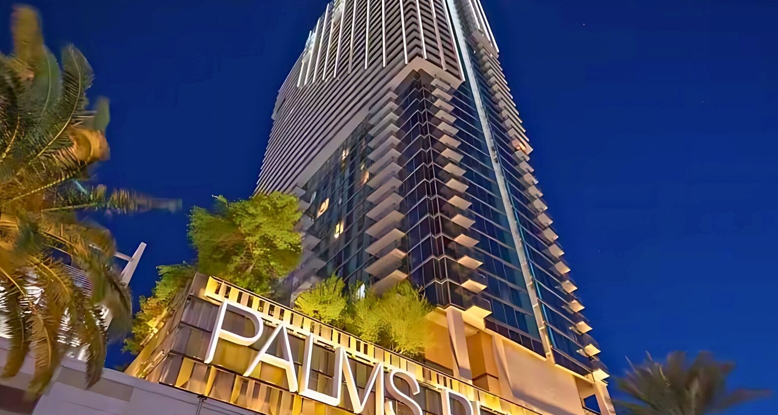 A tall, modern building with a prominent 'PALMS' sign at the base.