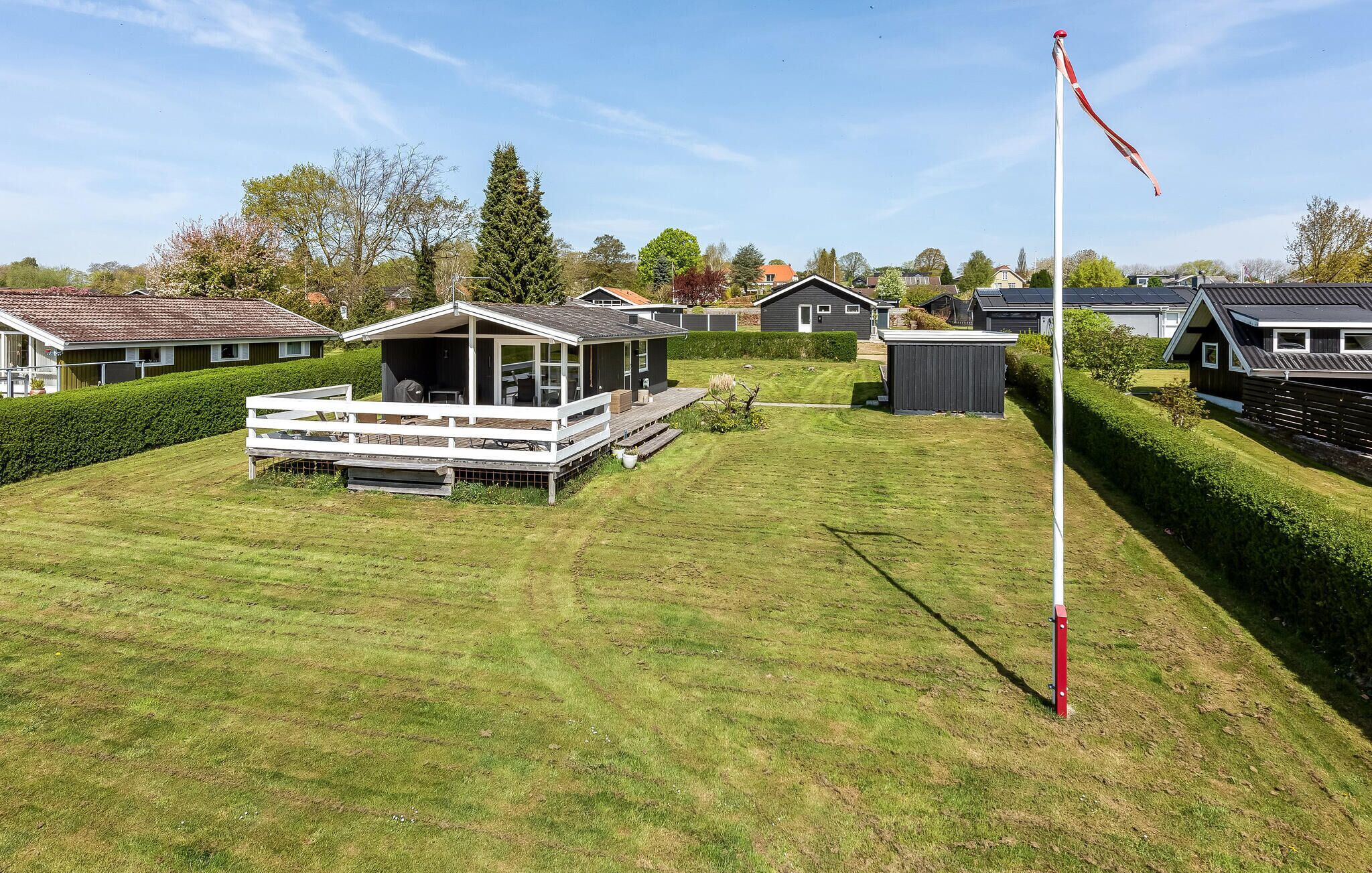 A residential area with houses, a flagpole, and a well-maintained lawn.