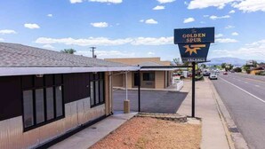 Un edificio con un letrero que dice "The Golden Spur" y un cartel vacío encima.
