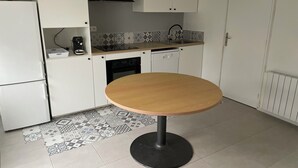 A compact kitchen with white cabinets, a black range hood, a coffee maker, and a dishwasher. - Country house 20 minutes from Puy du Fou (Mortagne-sur-Sèvre)