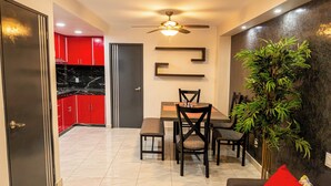 A modern living room with a dining area, a ceiling fan, and a large potted plant. - Flamingos 45 - Vacation Home for rent 5 min from Ixtapa's hotel zone! (Ixtapa-Zihuatanejo)
