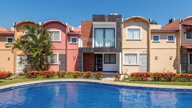A modern building with a swimming pool in front. - Flamingos 45 - Vacation Home for rent 5 min from Ixtapa's hotel zone! (Ixtapa-Zihuatanejo)