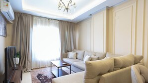 A modern living room with a sofa set, a coffee table, and a TV. - 2BRs CityStar Mall Apartment (Al Golf, Nasr City)