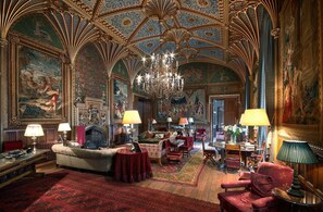 A grand room with ornate ceiling and detailed murals, furnished with plush seating and a chandelier. - Charming cottage in the heart of Ledbury (Ledbury)