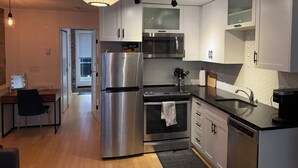 Een moderne keuken met roestvrijstalen apparatuur, witte kasten en een bijzondere backsplash van honingraatmozaïek.