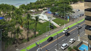 A coastal cityscape with a beach, palm trees, and a modern building.