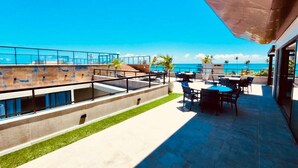 En tagterrasse med havudsigt, udendørs møbler og moderne arkitektur.