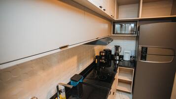 Una cocina compacta equipada con microondas, estufa y refrigerador.