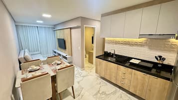 A modern kitchen with a black countertop, wooden cabinets, and a built-in oven.