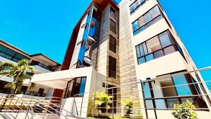 Un edificio moderno de varios pisos con amplias ventanas y un atrio central.