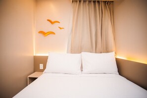 A hotel room with a bed, a nightstand, and a wall-mounted light fixture. - Oásis Porto de Galinhas - Flat na Praia (Ipojuca)
