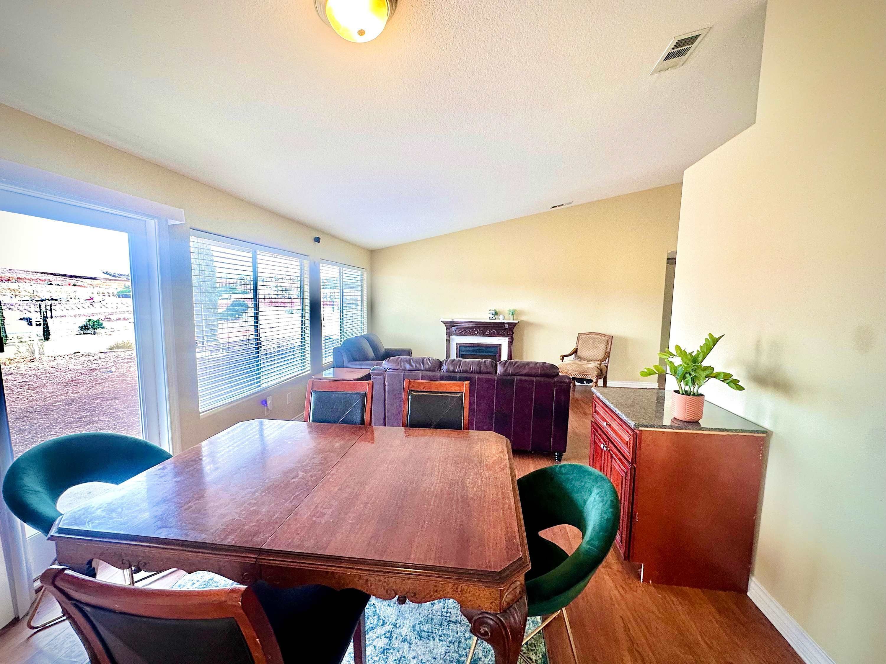 A dining area with a wooden table and chairs, a sofa, and a fireplace.
