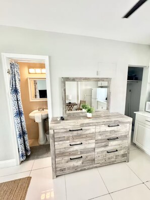 A modern bathroom with a wooden vanity, a sink, and a mirror.