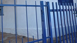 A white building with a blue metal gate and a window with blue shutters. - New Space - Grandma Dudu's Accommodations (Olímpia)
