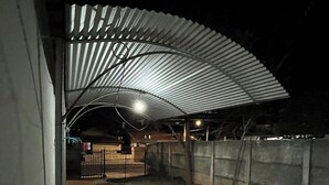 An outdoor covered area with a metal roof, concrete walls, and a gated entrance. - New Space - Grandma Dudu's Accommodations (Olímpia)