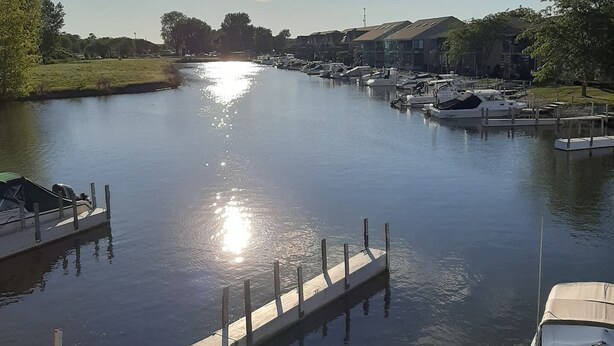 A calm waterway with boats docked, a wooden dock, and buildings in the background. - C&D REST-A-WHILE Book 2 Nights 3rd Is Free 9-1-26 to 9-27-26 Stays Only (Oak Harbor)