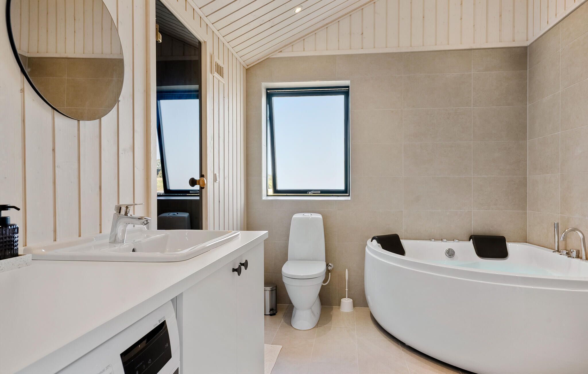 A modern bathroom with a freestanding bathtub, a toilet, and a sink.