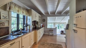 A kitchen with wooden cabinets, a sink, and a refrigerator.