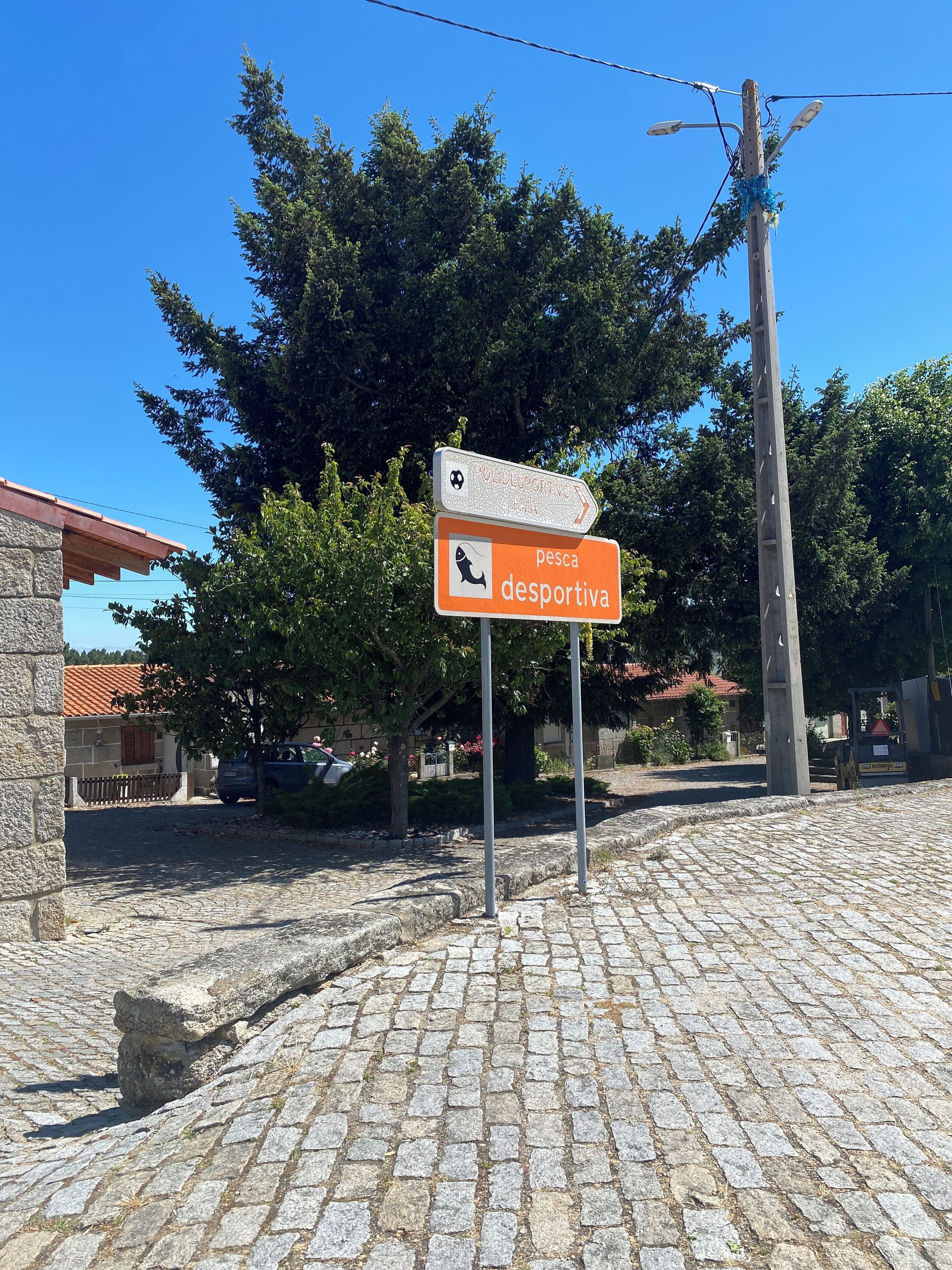 A cobblestone street with a sign indicating a sports fishing area.