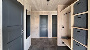 A hallway with wooden walls and doors, grey storage units, and a tiled floor. - Awesome home in Gålå with sauna (Gålå)