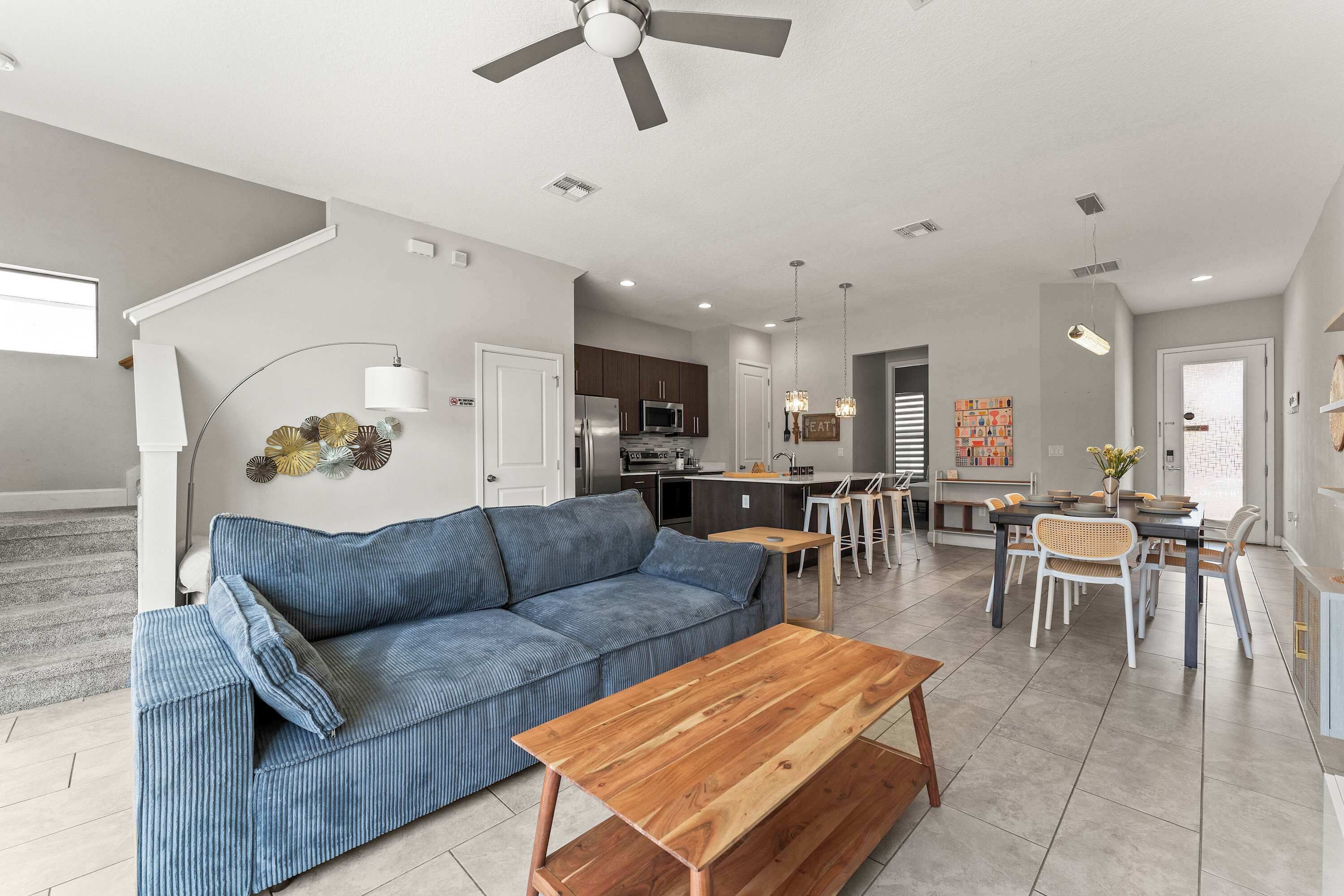 A modern living room with a sofa, coffee table, and dining area.