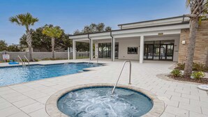 A swimming pool with a hot tub, a covered patio area, and a building with a restaurant sign. - Chic Villa Domani Retreat 9ppl (Davenport)