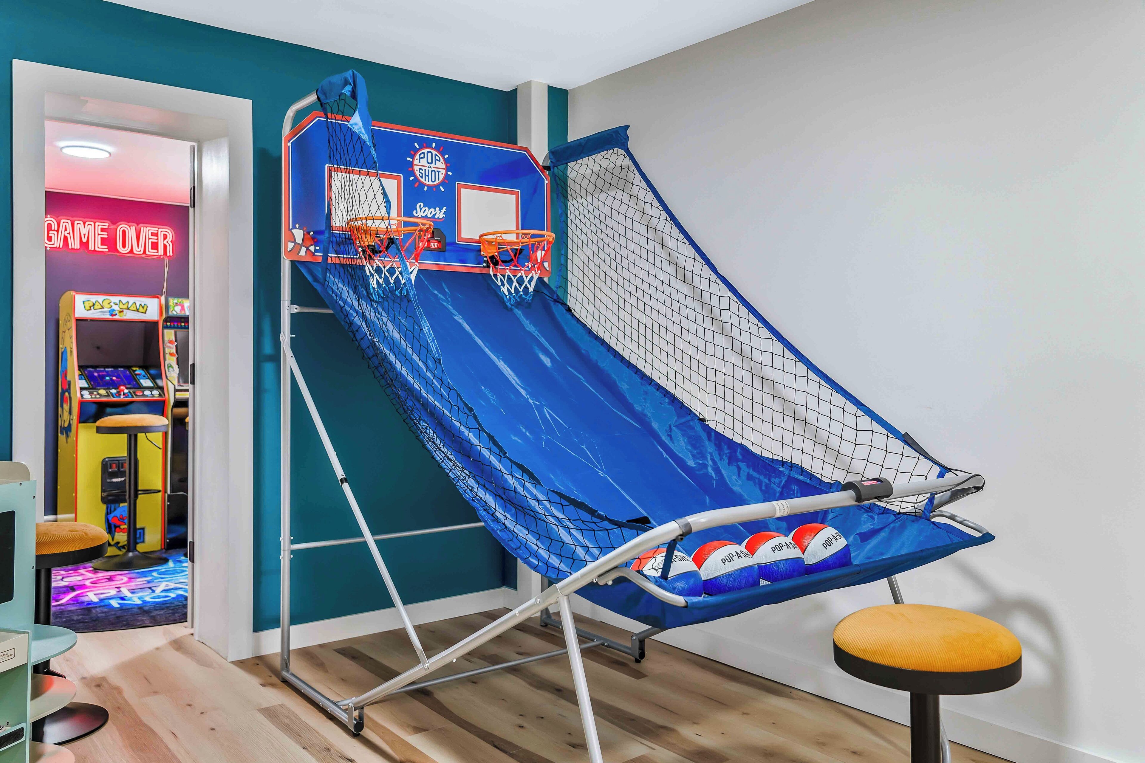 Un toboggan bleu avec une partie supérieure en filet, un panier de basket et, au fond, un panneau indiquant « PARTIE TERMINÉE ».