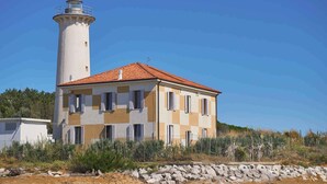 Un bâtiment situé sur la côte, doté d’un phare et d’une façade à motifs géométriques.
