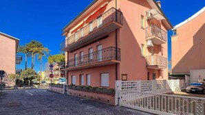 Un immeuble à plusieurs étages doté de balcons, d’une entrée sécurisée et surplombant un ciel d’un bleu éclatant.