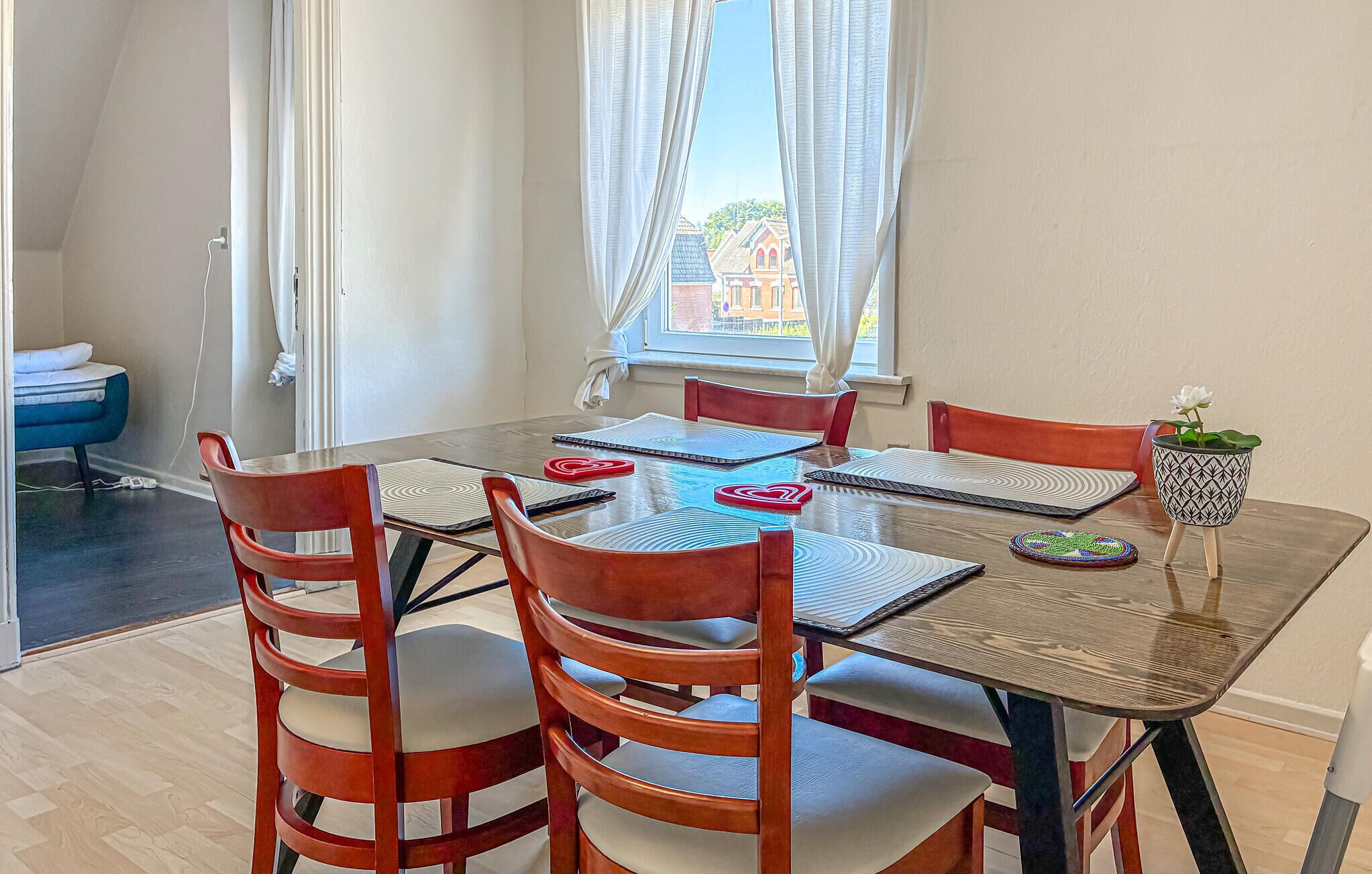 Un comedor con mesa, sillas y vistas de edificios.