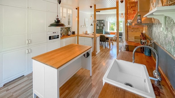 A modern kitchen with white cabinetry, a wooden countertop, a built-in oven, and a sink. - Nice home in Värnamo with sauna (Värnamo)