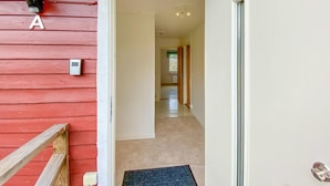 A red exterior wall with a white door and a wooden staircase. - Beautiful apartment in Pauliström (Pauliström)