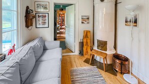 A cozy living room with a grey sofa, a fireplace, and a bookshelf. - Beautiful home in Gunnarsbytorp with sauna (Gunnarsbytorp)