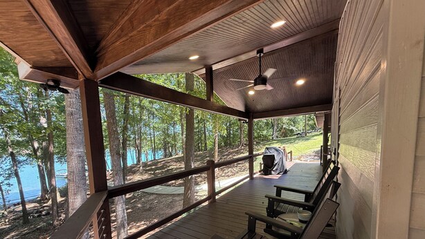 Un espacio al aire libre cubierto con bancos de madera y vista a un lago.