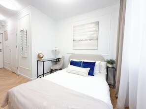 Ein Hotelzimmer mit einem großen Bett, einem Schreibtisch, einem Stuhl und einem an der Wand befestigten Globus.