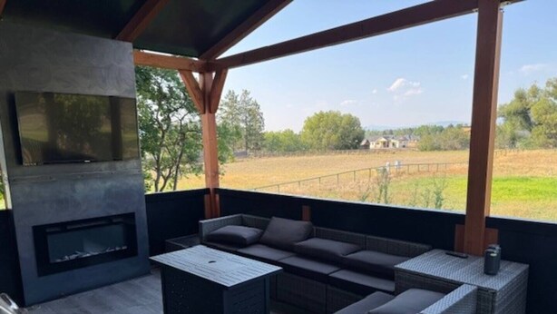 An outdoor patio with a built-in grill, a sofa, and a table.